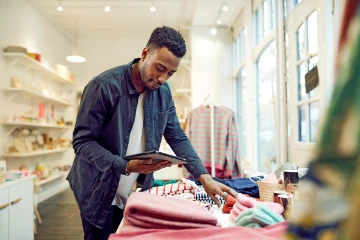 Man looking at clothes while using a tablet