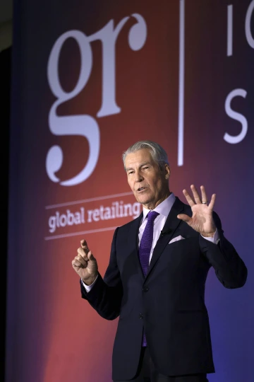 Man speaking on stage at a conference