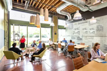 A photograph of individuals sitting in an office space. 