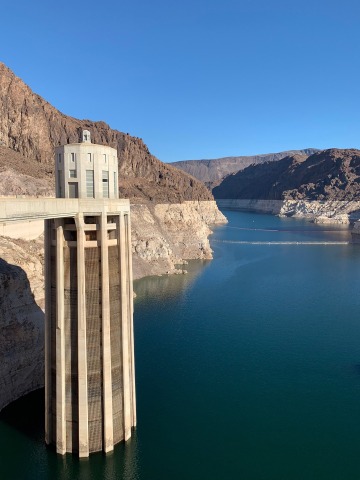 A photograph of Lake Mead, “bathtub rings”  the white portion of the rock walls show that water levels were once much higher. This photo was taken from Hoover Dam in December 2022.