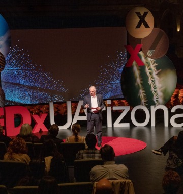 A photograph of President Robbins speaking at the TEDxUArizona event