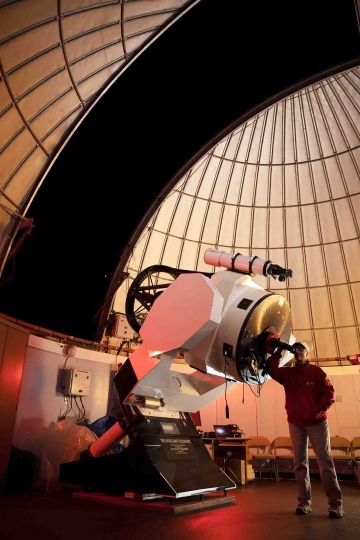 Individual stands near advanced telescope 