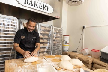 Man kneads dough in bakery