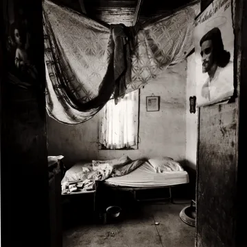 A photograph of a bedroom with photos of religious posters. 