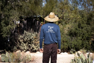 Lancaster wearing a shirt that says "Plant the Rain to grow abundance"