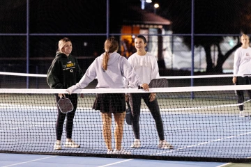 Three students standing and chatting on the court