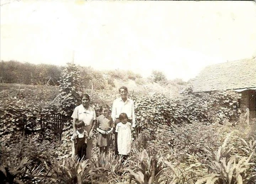 A black and white photo of Michael Kotutwa Johnson’s grandfather, Fred Aptvi Johnson (R), and grandmother Minnie (L) with his father Caleb (L) and two aunts in Lower Moencopi on the Hopi Reservation. 