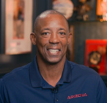 Sean Elliot smiling, wearing a red and blue Arizona polo 