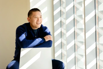 A photograph of Rui Chang leaning onto a chair