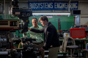 A photograph of Mark Jendrisak and Akrum Tamimi working with machinery together