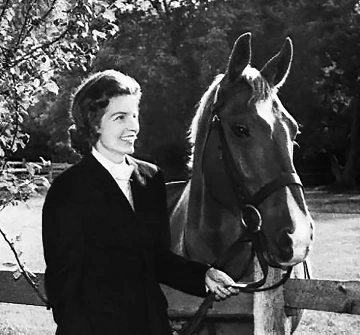 A black and white photograph of Lucia Nash with a horse