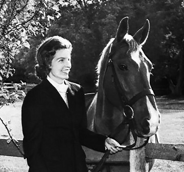 A black and white photograph of Lucia Nash with a horse
