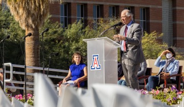A photograph of University of Arizona President Robert C. Robbins, M.D. addressing a crowd.