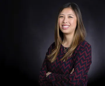 A headshot of Gain Jue against a dark backdrop 