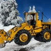Alyson Ford is pictured driving a yellow front loader with snow chains