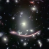 The galaxy Abell 370 appears twice in this image taken with the Hubble Space Telescope: as a normal galaxy and a drawn-out smear of light due to gravitational lensing. 